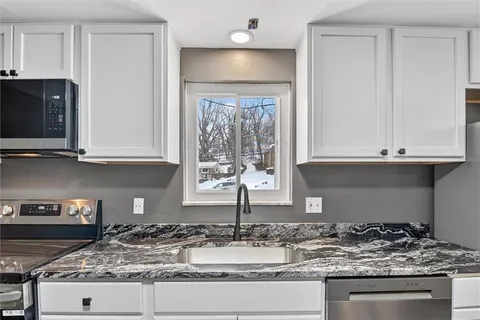 a kitchen with granite countertop a sink and a stove