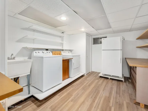 a view of a kitchen with refrigerator and wooden floor