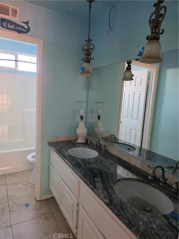 a bathroom with a granite countertop sink a mirror and a bathtub
