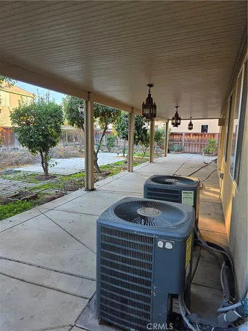 a view of a patio with lawn chairs under an umbrella
