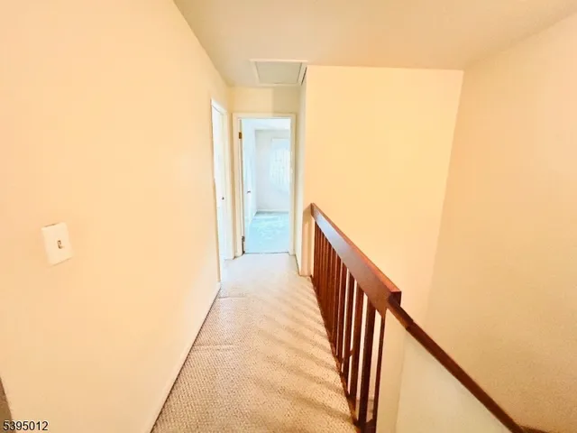 a view of a hallway with wooden floor and stairs