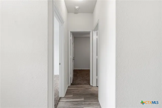 a view of a hallway with wooden floor