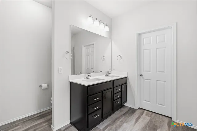 a bathroom with a double vanity sink and mirror