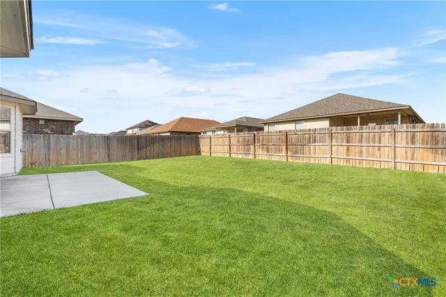 a view of a yard in front of a house with a garden