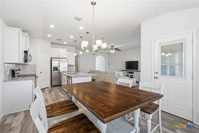 a large kitchen with sink a refrigerator and a stove top oven