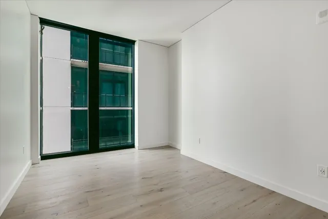 a view of an empty room with closet and a window