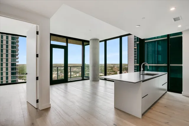 a living room with hardwood floor and large window