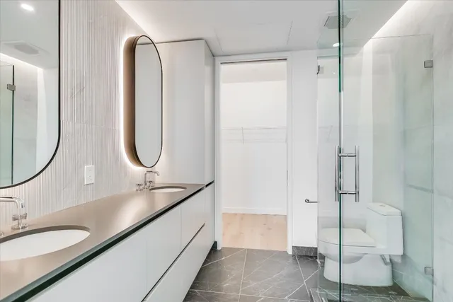 a en suite bathroom with a granite countertop sink and a mirror