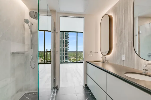 a en suite bathroom with a double vanity sink and a mirror