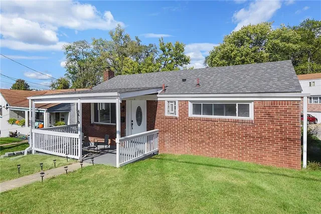 a view of house with a yard and deck