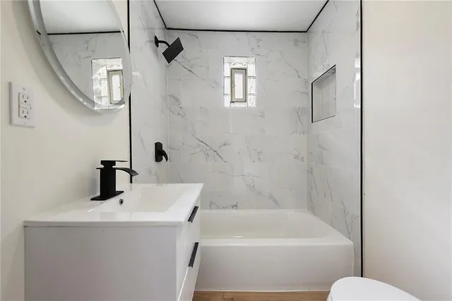 a bathroom with a sink a toilet and shower