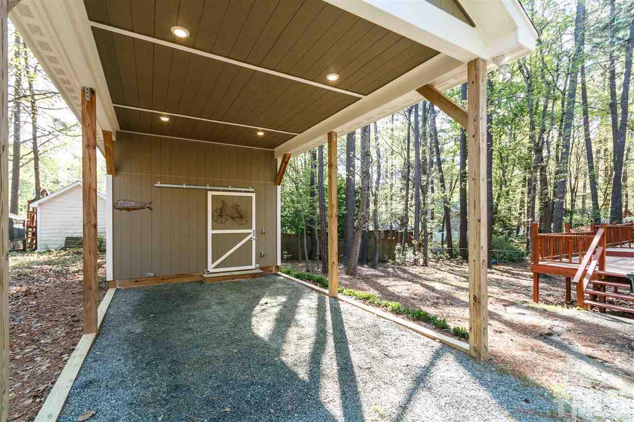 7420 Old Fox Trail Raleigh, NC 27613 - Photo 26 of 28 a porch with a table and chairs next to a yard