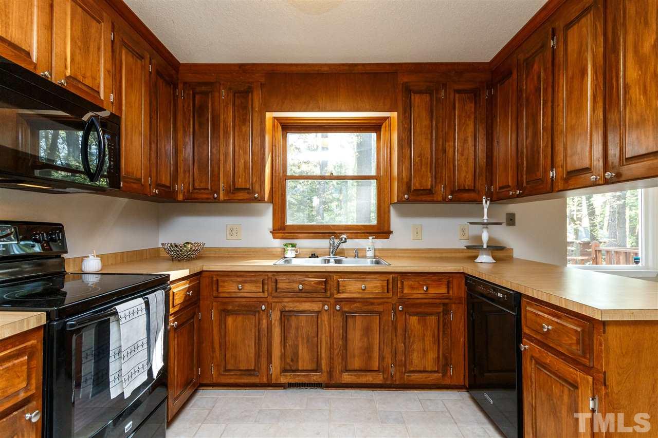 7420 Old Fox Trail Raleigh, NC 27613 - Photo 8 of 28 a kitchen with a sink stove top oven and cabinets