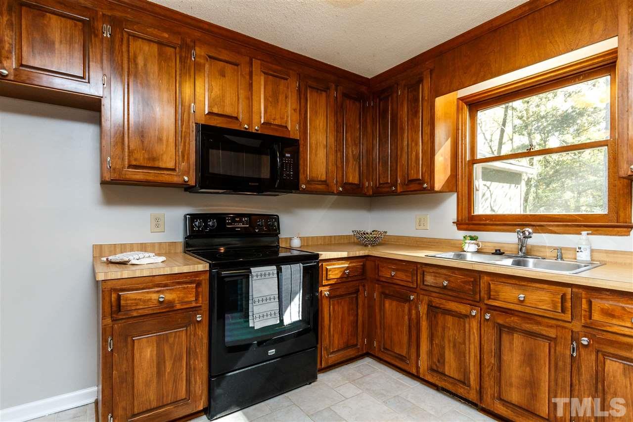 7420 Old Fox Trail Raleigh, NC 27613 - Photo 9 of 28 a kitchen with granite countertop wooden cabinets stainless steel appliances and a window