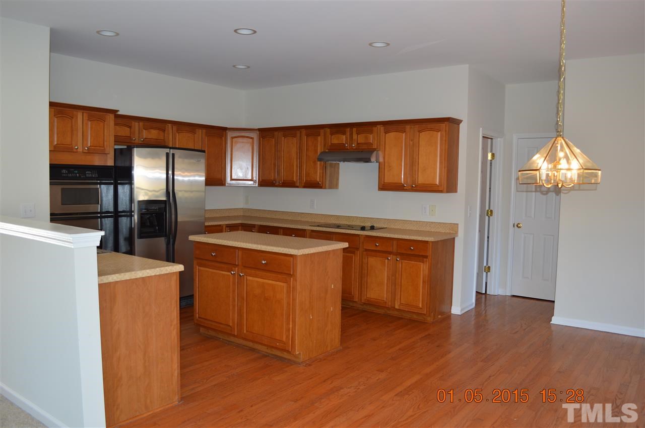 3216 Forest Mill Circle Raleigh, NC 27616 - Photo 6 of 25 a kitchen with stainless steel appliances granite countertop a refrigerator a stove and a wooden floors