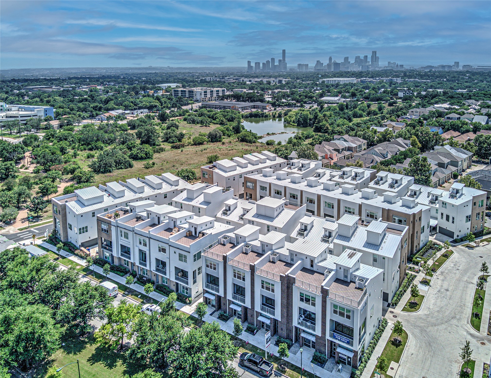 2805 McCurdy Street, Unit 14 Austin, TX 78723 - Photo 36 of 40 City skyline views from modern townhomes, nestled beside a serene pond.