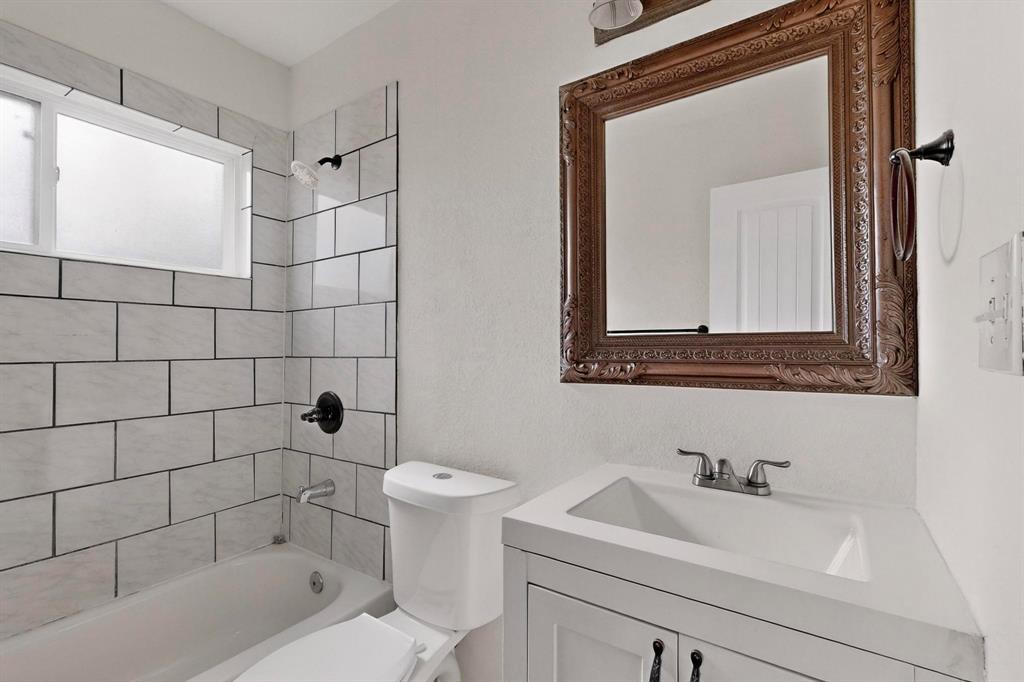 401 East Miller Road Garland, TX 75041 - Photo 18 of 18 a bathroom with a sink mirror toilet and bathtub