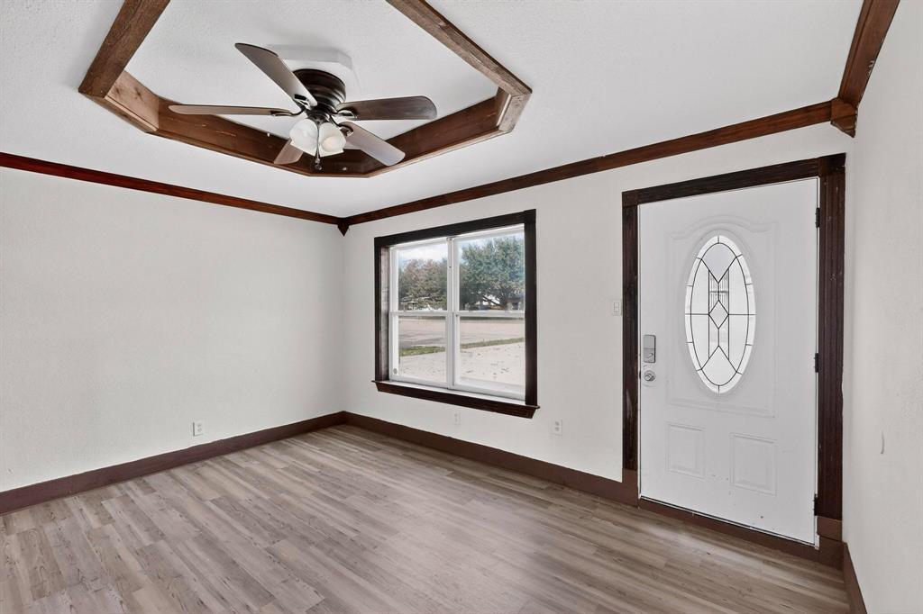 401 East Miller Road Garland, TX 75041 - Photo 3 of 18 a view of a hallway with wooden floor and a ceiling fan