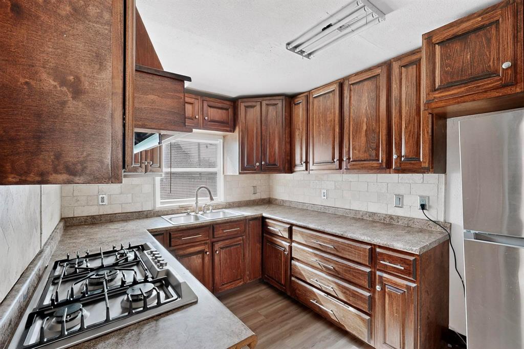 401 East Miller Road Garland, TX 75041 - Photo 6 of 18 a kitchen with wooden cabinets and a stove top oven