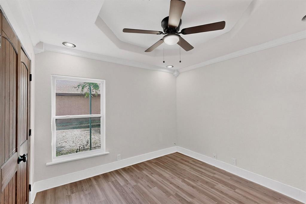 401 East Miller Road Garland, TX 75041 - Photo 10 of 18 an empty room with a window and a ceiling fan
