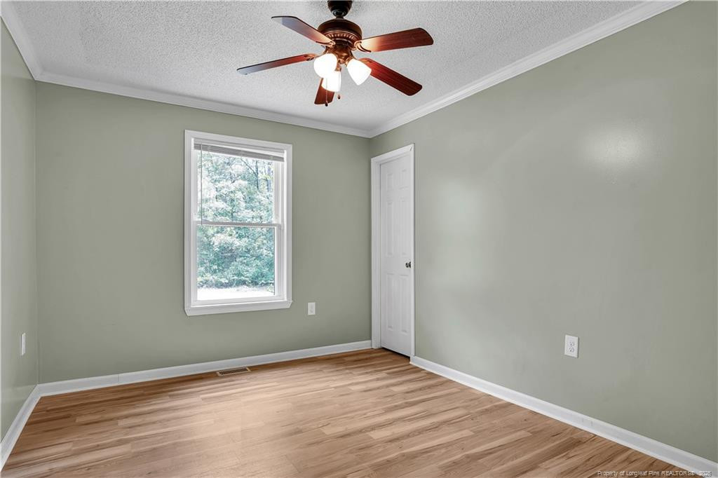 8155 Arabia Road Lumber Bridge, NC 28357 - Photo 18 of 30 a view of an empty room with window and a chandelier fan