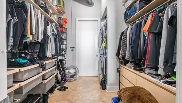 a view of walk in closet with clothes and shoes