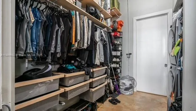a view of walk in closet with clothes and shoes