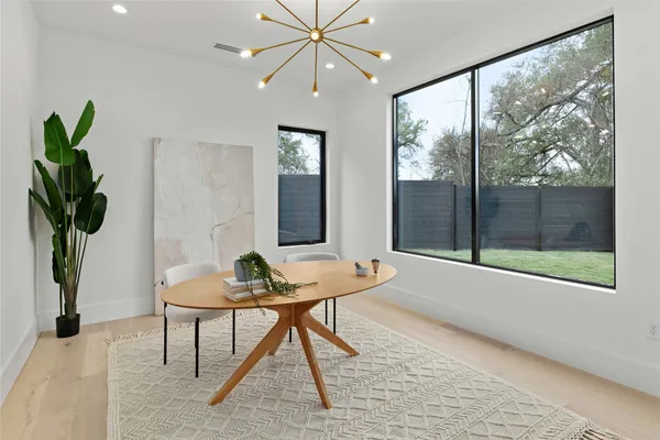 a dining room with furniture and a potted plant