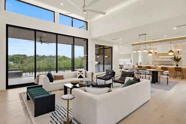 a living room with couches and a large window with garden view