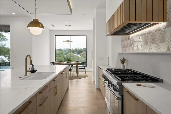 a kitchen with stainless steel appliances a sink a stove and a wooden floors