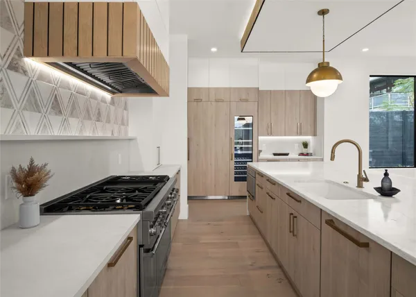 a kitchen with stainless steel appliances a stove a sink and a refrigerator
