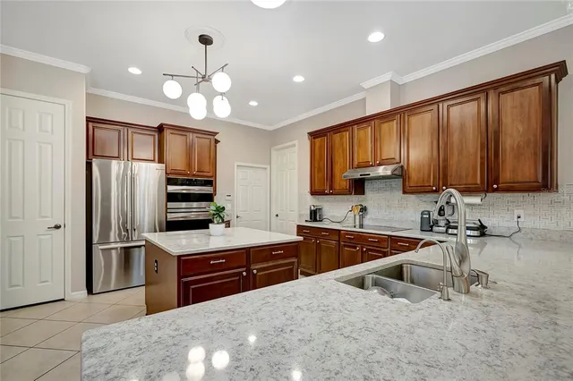 a kitchen with a dining table chairs and a view of living room