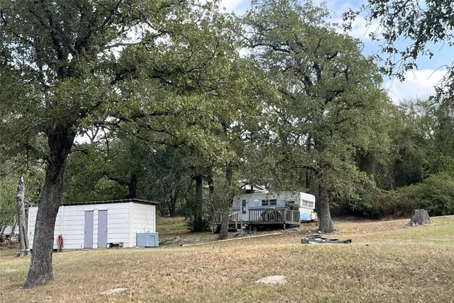 a backyard of a house with cars parked and parked