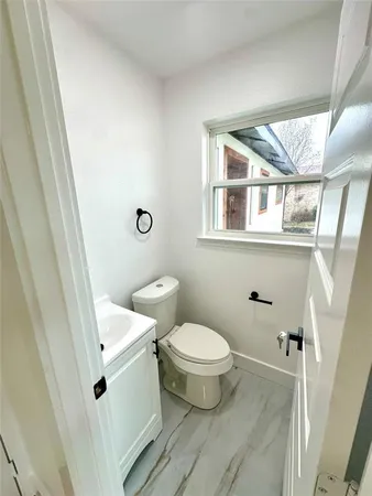 a white toilet sitting next to a bathroom sink and a mirror
