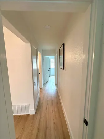 a view of a hallway with wooden floor