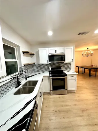 a kitchen with granite countertop a sink and steel appliances