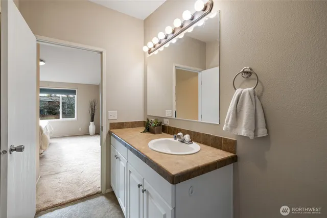 a bathroom with a sink vanity and mirror
