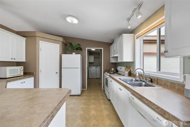 a large kitchen with stainless steel appliances granite countertop a refrigerator and a sink