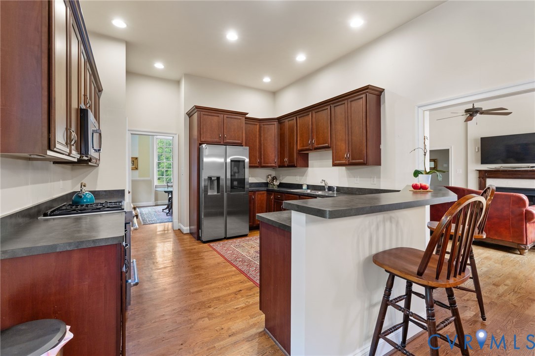 13173 Scotchtown Road Beaverdam, VA 23015 - Photo 25 of 65 a kitchen with stainless steel appliances granite countertop wooden cabinets a refrigerator a stove a sink and a chairs