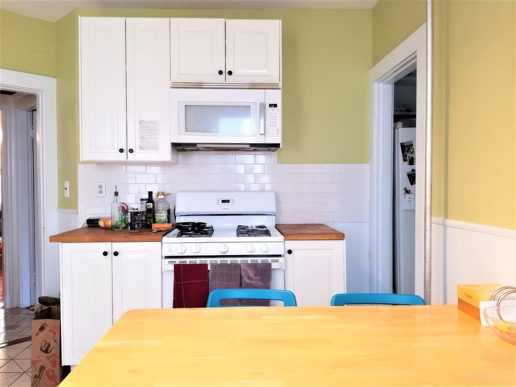 119 Browne Street, Unit 1 Brookline, MA 02446 - Photo 8 of 15 a kitchen with stainless steel appliances granite countertop a stove a sink and a microwave