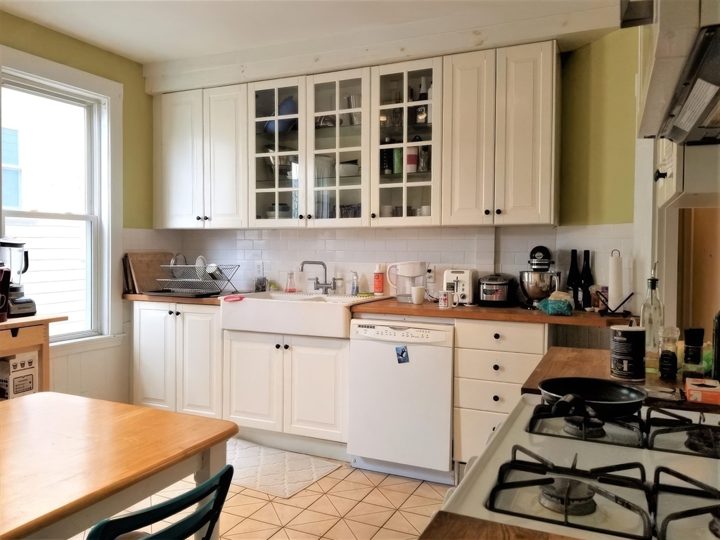 119 Browne Street, Unit 1 Brookline, MA 02446 - Photo 9 of 15 a kitchen with stainless steel appliances a stove a sink and a refrigerator
