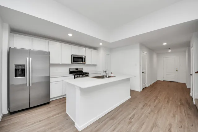 a kitchen with stainless steel appliances a refrigerator and a stove top oven