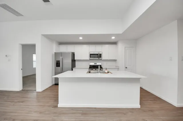 a kitchen with kitchen island a sink stainless steel appliances and cabinets