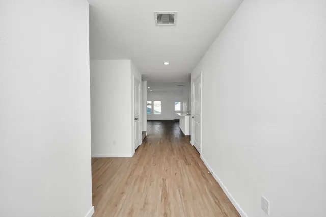 a view of a hallway with wooden floor