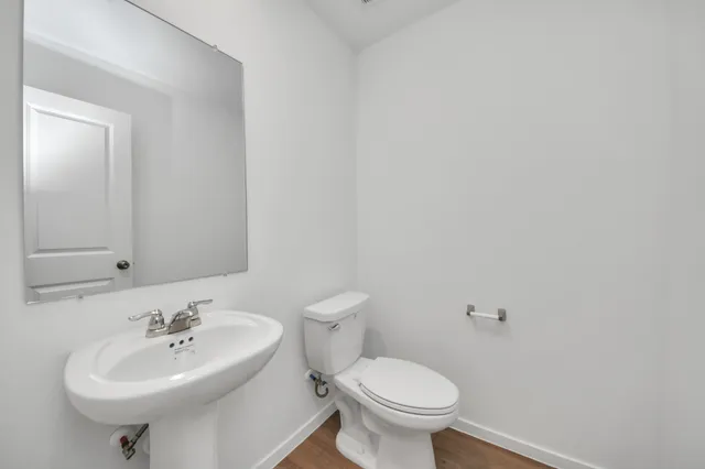 a bathroom with a sink a toilet and mirror