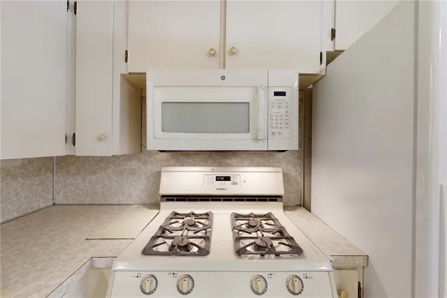 a kitchen with white cabinets stainless steel appliances and sink