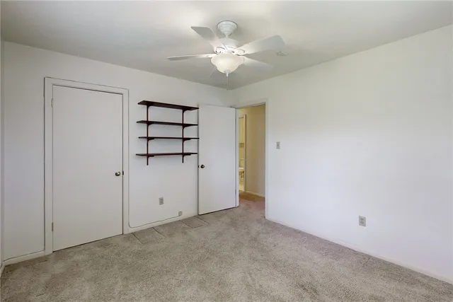 an empty room with fan and windows