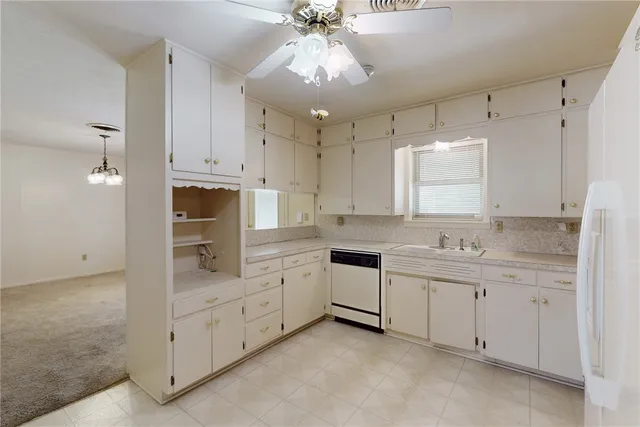 a kitchen with white cabinets and white appliances