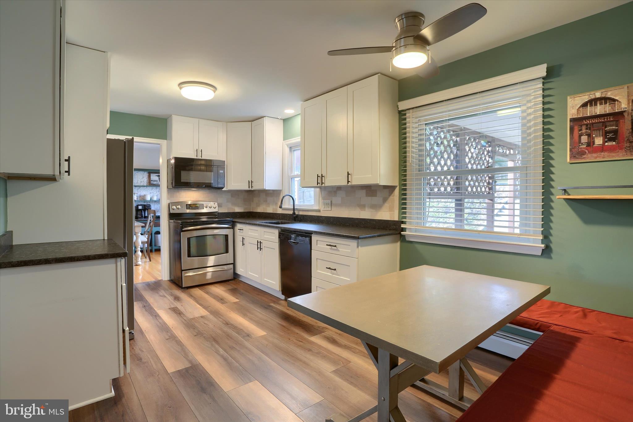 1288 Copeland School Road West Chester, PA 19380 - Photo 5 of 36 a kitchen with stainless steel appliances granite countertop a stove a sink dishwasher a microwave oven and a dining table with wooden cabinet