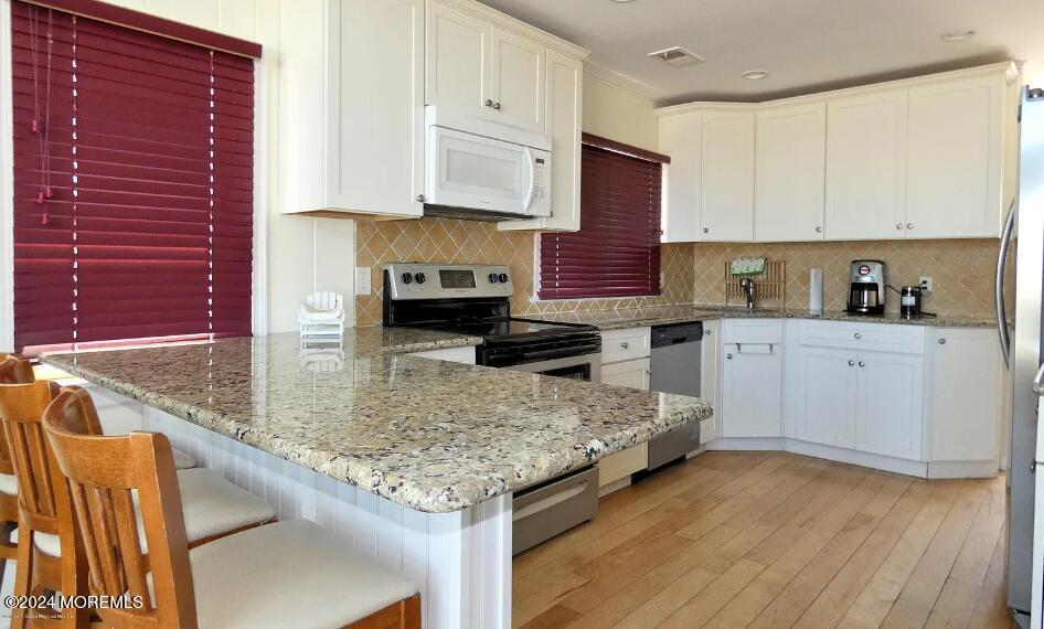 3164 Ocean Road Lavallette, NJ 08735 - Photo 5 of 14 a kitchen with stainless steel appliances granite countertop a sink stove and cabinets